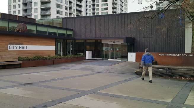 man waling past city hall.