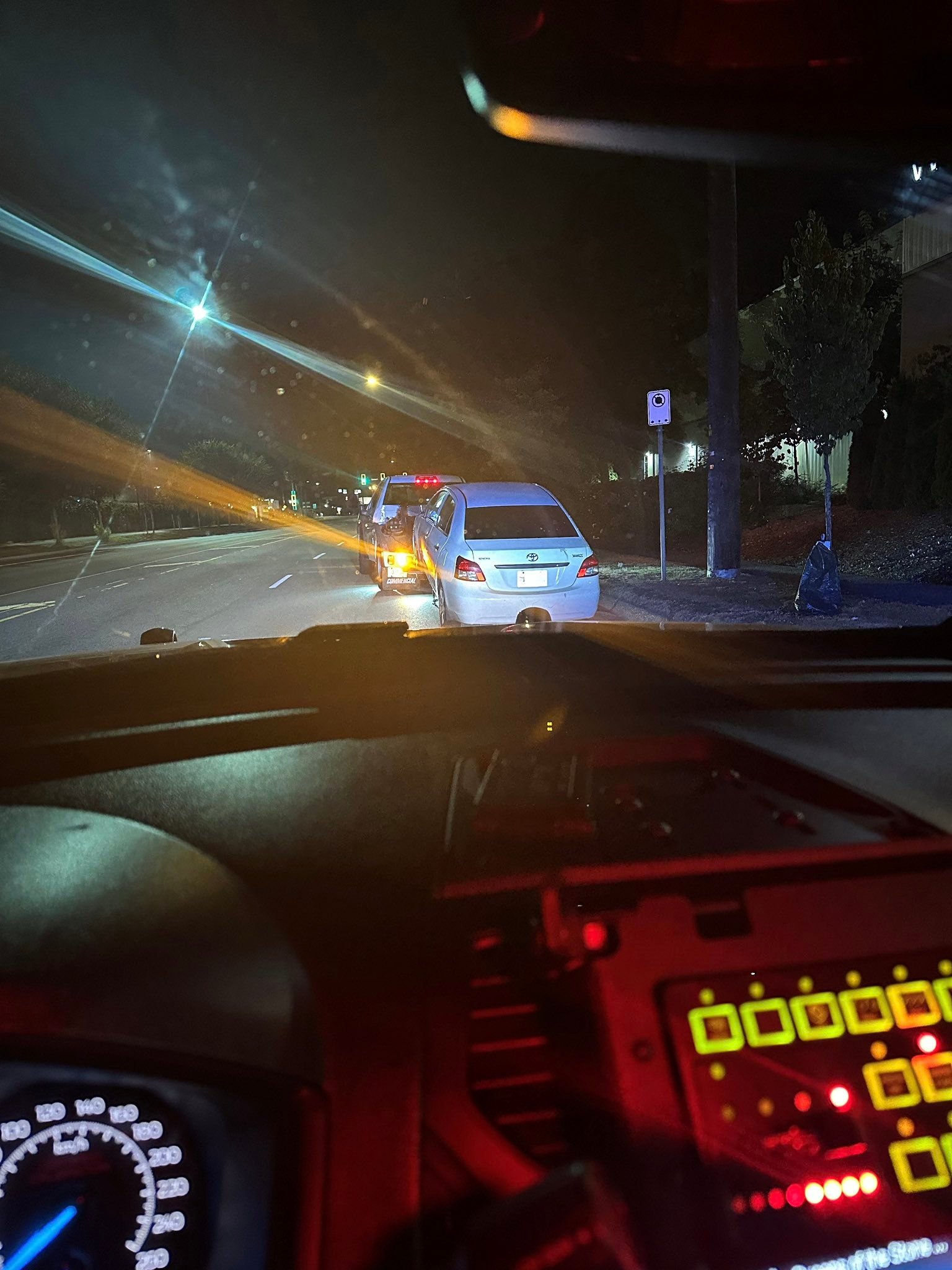 North Vancouver RCMP vehicle stop at night with a learner driver pulled over and a tow truck ahead.