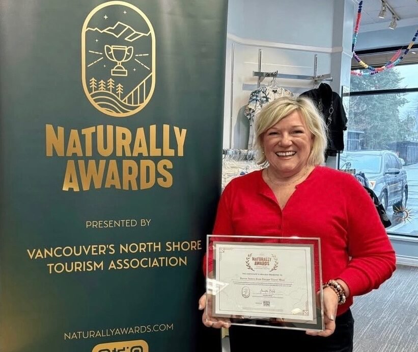 Karen of Escape Travel Wear holding a Naturally Awards certificate at the North Vancouver boutique